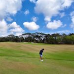 Pegolf bersiap memainkan pukulan di lapangan golf sebagai simbol fokus dan pengendalian diri