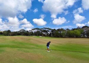 Pegolf bersiap memainkan pukulan di lapangan golf sebagai simbol fokus dan pengendalian diri