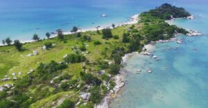 Keindahan Pantai Tanjung Berikat dengan pasir putih dan laut biru.