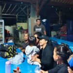 Orang-orang duduk bersama, makan, tertawa, dan bernyanyi di Bali.