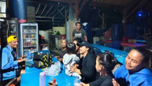 Orang-orang duduk bersama, makan, tertawa, dan bernyanyi di Bali.