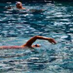 Orang berenang di kolam sebagai aktivitas olahraga dan rekreasi.