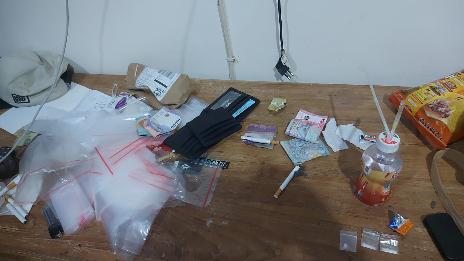 Barang bukti berupa kantong plastik berisi narkotika dan timbangan digital di atas meja hasil penggerebekan BNN Kota Denpasar.