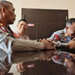 Personel berseragam tersenyum sebagai gambaran sisi manusiawi di balik tugas.