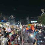 Suasana pasar malam yang ramai dengan pedagang kuliner, pakaian, minuman, dan aksesori.